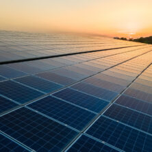 blaue-photovoltaik-sonnenkollektoren-die-auf-dem-dach-des-gebaeudes-montiert-sind-um-bei-sonnenuntergang-sauberen-oekologischen-strom-zu-erzeugen-produktion-eines-erneuerbaren-energiekonzepts